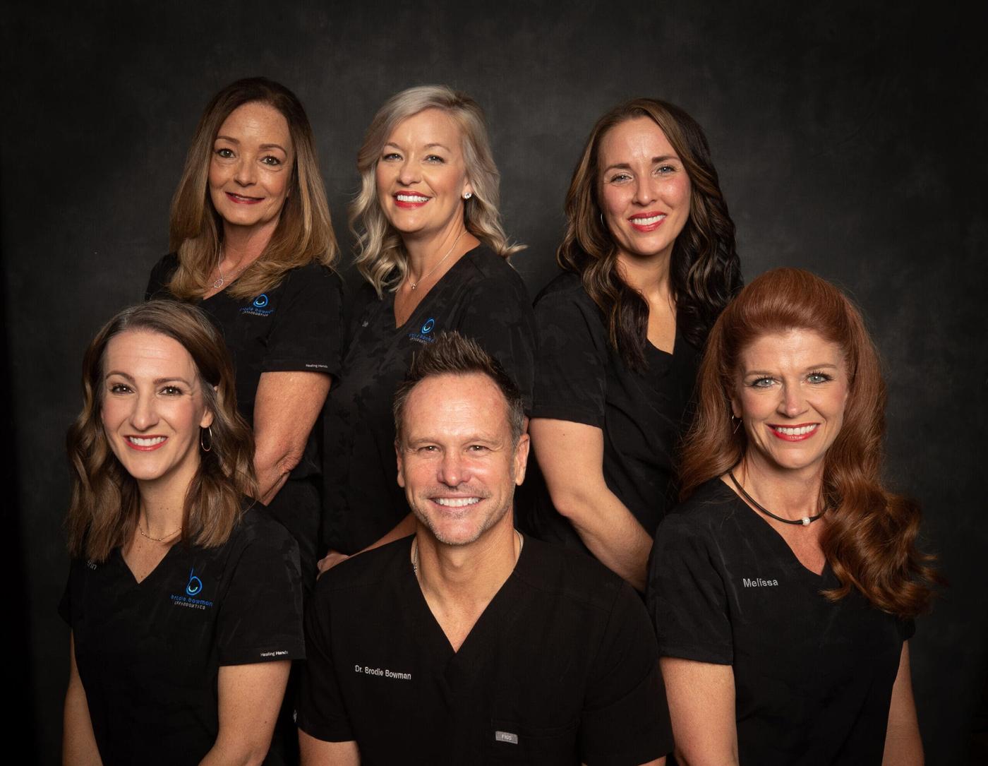 The Brodie Bowman Orthodontics team in a studio group portrait, the practice serving Crestview, FL from Fort Walton Beach