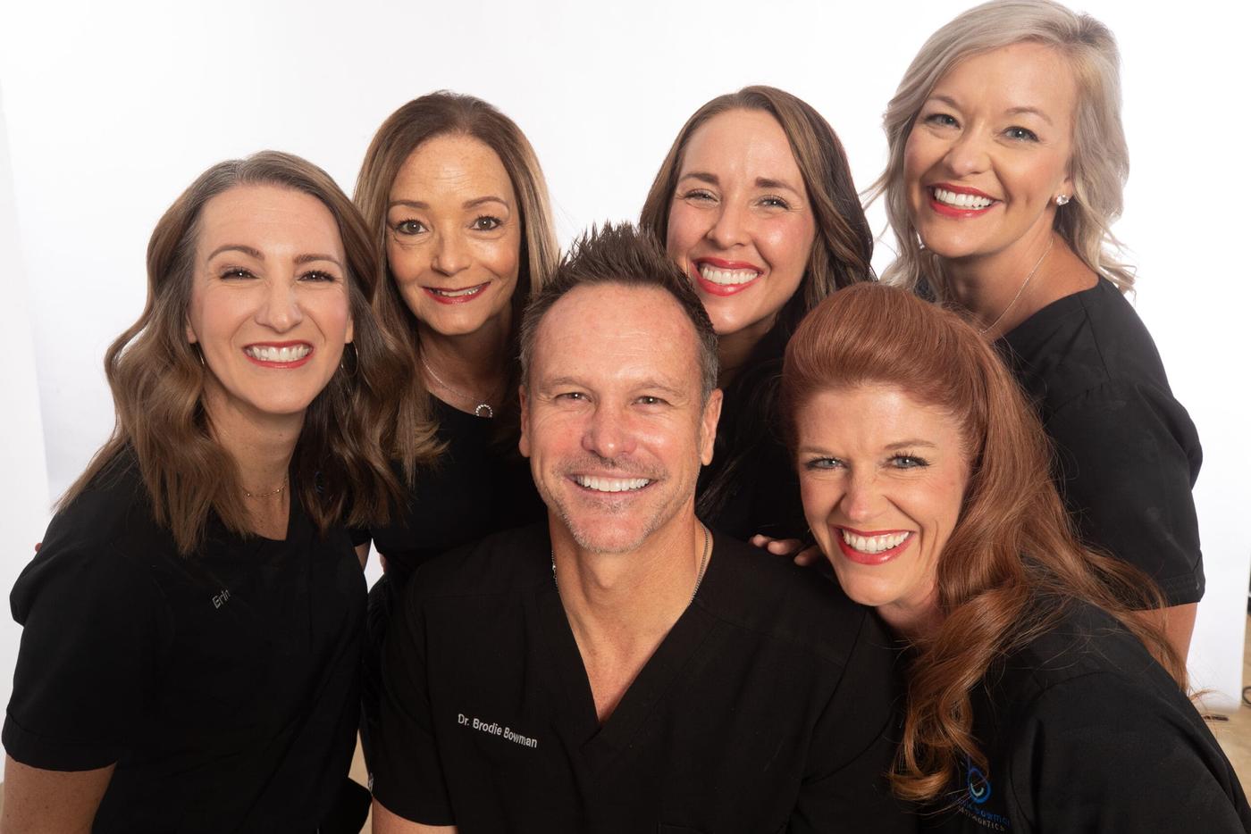 The Brodie Bowman Orthodontics team, including Niceville-area locals Erin and Melissa, smiling in black scrubs