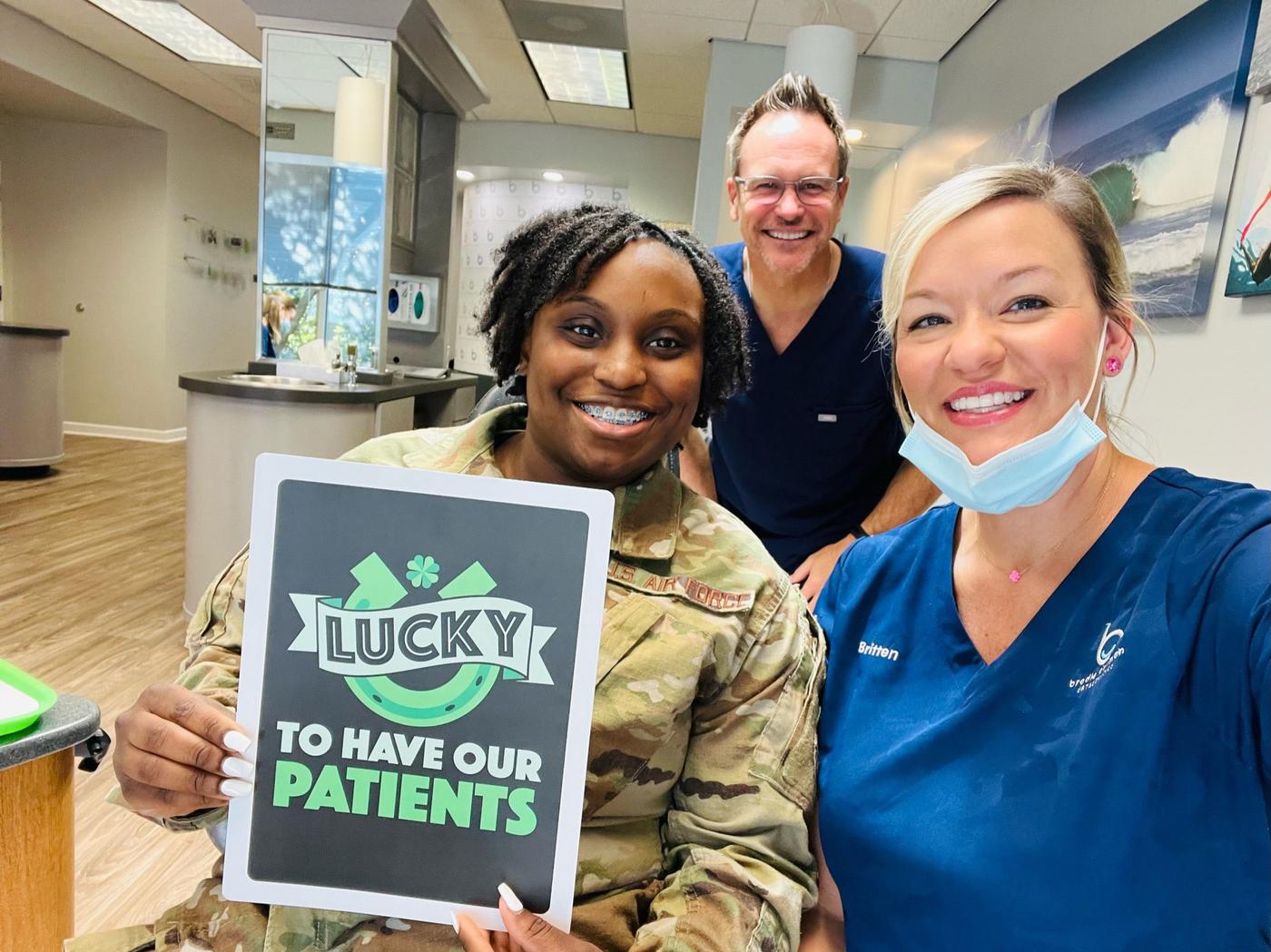 Dr. Bowman and assistant Britten at Brodie Bowman Orthodontics with an Air Force patient in braces